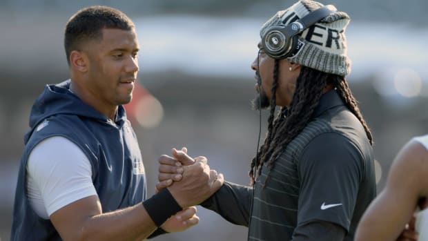 Seahawks quarterback Russell Wilson and Raiders running back Marshawn Lynch embrace before a game.